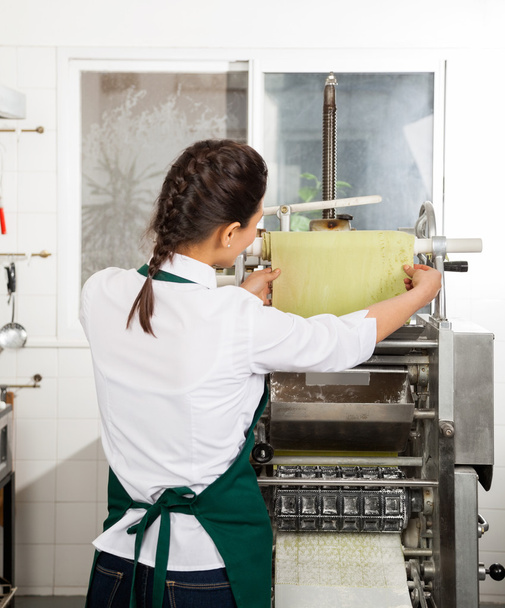 Female Chef Processing Pasta Sheet In Machine - Photo, image