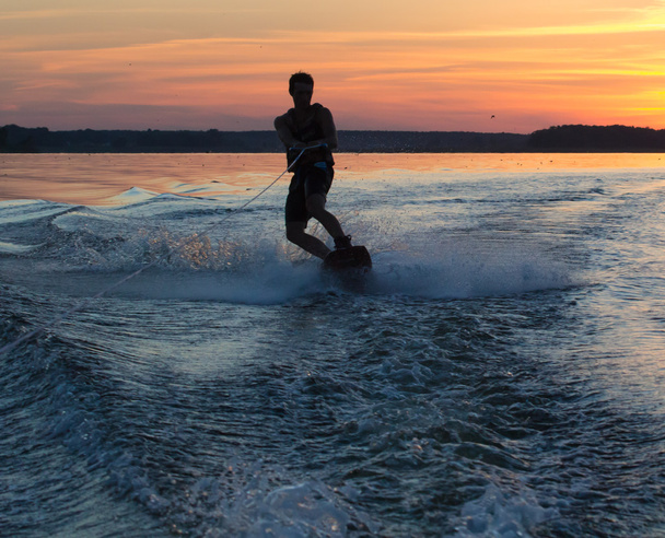 Wakeboarder macht Tricks bei Sonnenuntergang - Foto, Bild