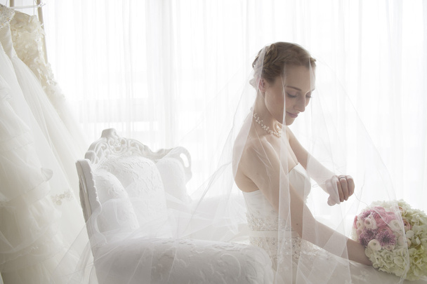 Bride smiling gently sat in a chair - Foto, immagini