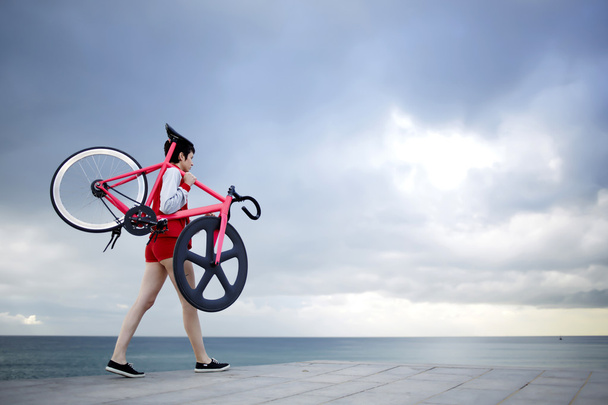 woman holding her light weight bike - 写真・画像