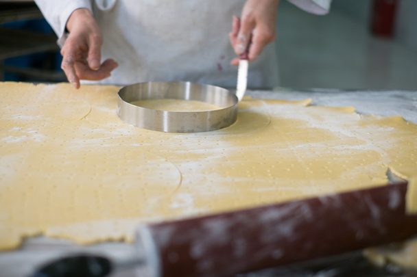 Panadero cortando corteza de pastel
  - Foto, imagen