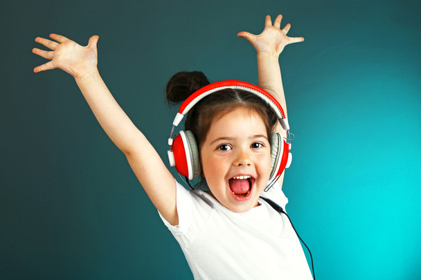 Beautiful little girl listening to music on color background - Foto, immagini