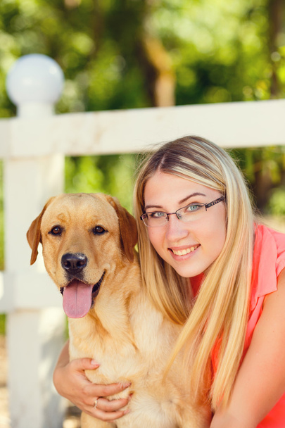 portrait of Beautiful young girl with her dog labrador retriever outdoor in summer beautiful park  - Foto, Imagen