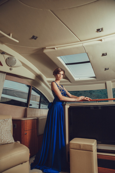Beautiful young sexy girl in a dress and makeup, summer trip on a yacht with white sails on the sea or ocean - Photo, Image