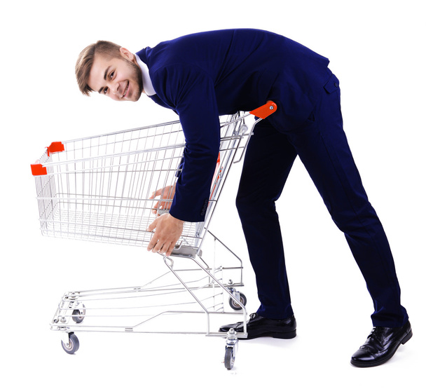 Young man with empty shopping cart, isolated on white - Photo, image