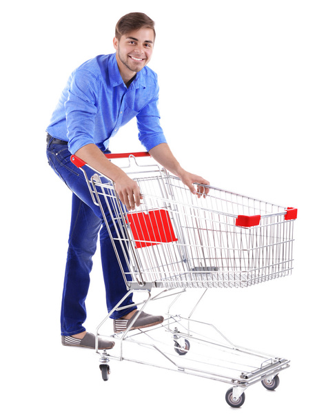 Young man with empty shopping cart, isolated on white - Fotó, kép