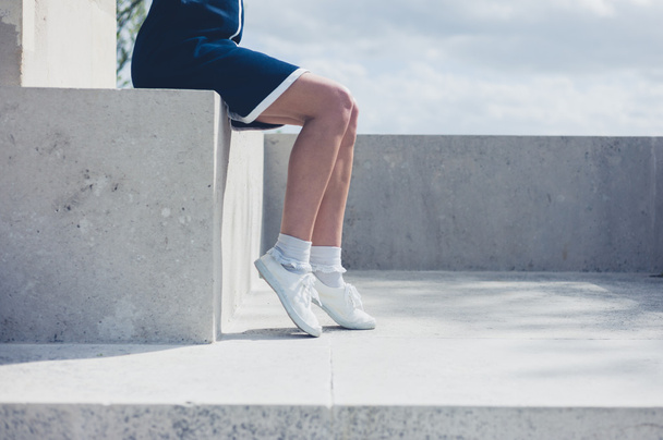 Young woman sitting on a concrete wall - Foto, Bild