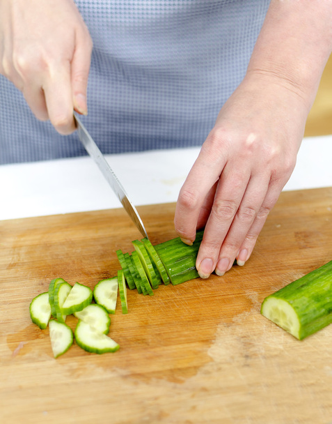 Mains de femme coupant le concombre
 - Photo, image