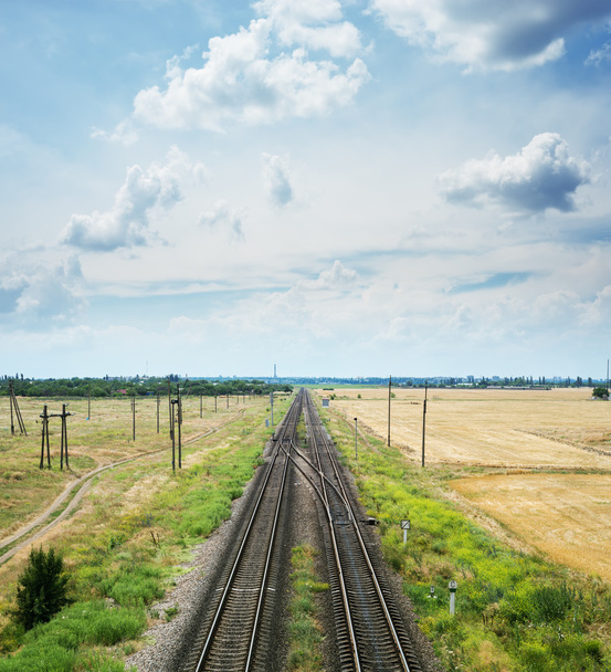 two railways with crossing under dramatic sky with clouds - Foto, Imagen