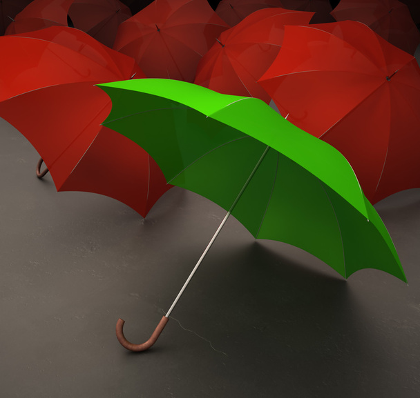 groene paraplu met rode paraplu's op de achtergrond - Foto, afbeelding