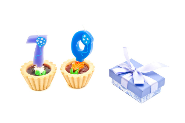 cakes with seventy years birthday candles and gift on white - Фото, зображення