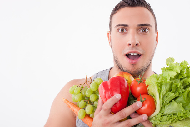 Cheerful young fit man likes healthy food - 写真・画像