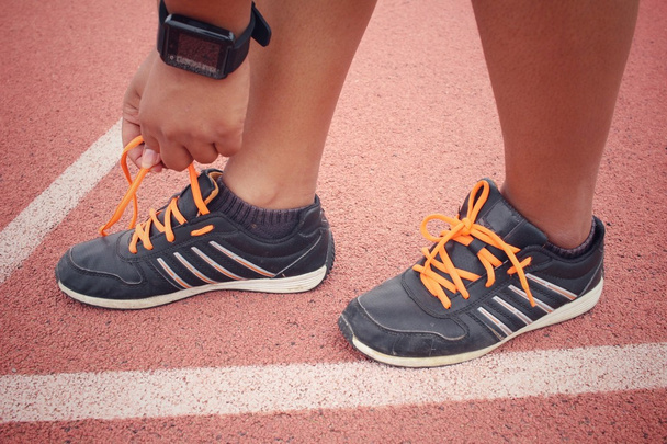 Mujer manos atando cordones de zapatos con smartwatch
 - Foto, imagen