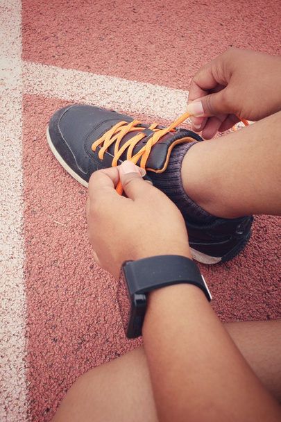 Mujer manos atando cordones de zapatos con smartwatch
 - Foto, imagen