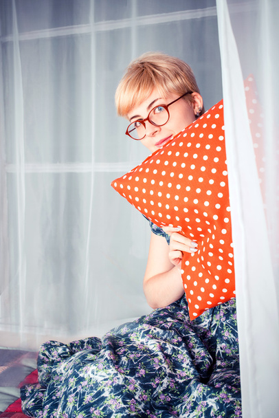 Cute little girl playing hide and seek with curtains sitting on a window sill - Photo, Image
