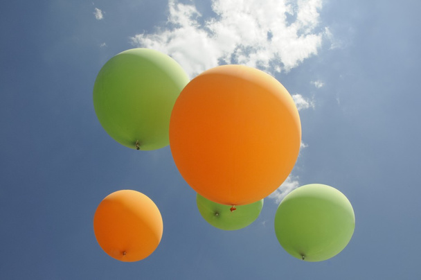 Des ballons à air vert et orange planent vers le soleil
 - Photo, image