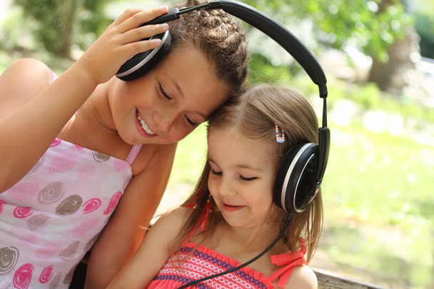 Hermanas escuchan la música juntas
 - Foto, imagen