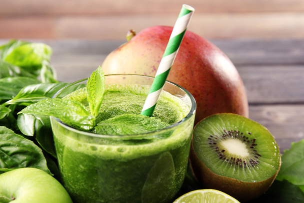 Green healthy juice with fruits and herbs on table close up - Фото, зображення