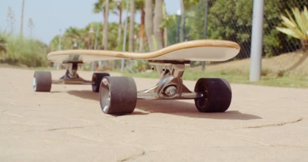 longboard spoczywa na ziemi na ulicy - Materiał filmowy, wideo