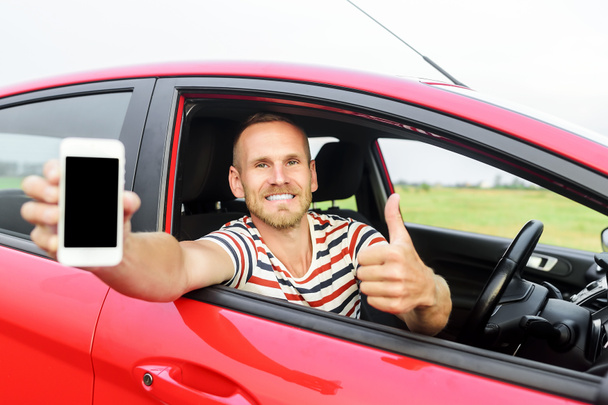 Man in car showing smart phone. - Photo, Image