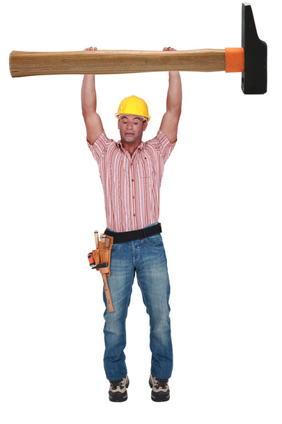 Young laborer hung to a huge hammer on white background - Fotoğraf, Görsel
