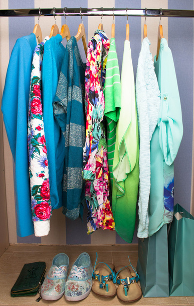 Ropa femenina de color en perchas en el armario
 - Foto, imagen