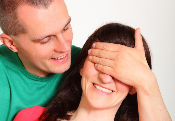 Мужчина закрывает глаза женщины для сюрприза
 - Фото, изображение