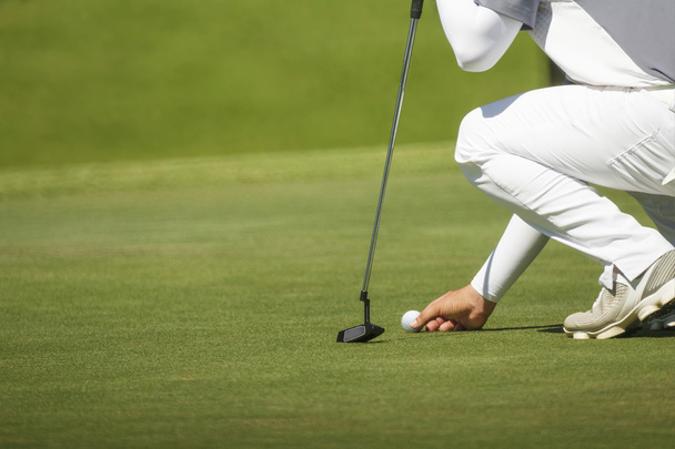 golfista segna la sua posizione su un verde
  - Foto, immagini