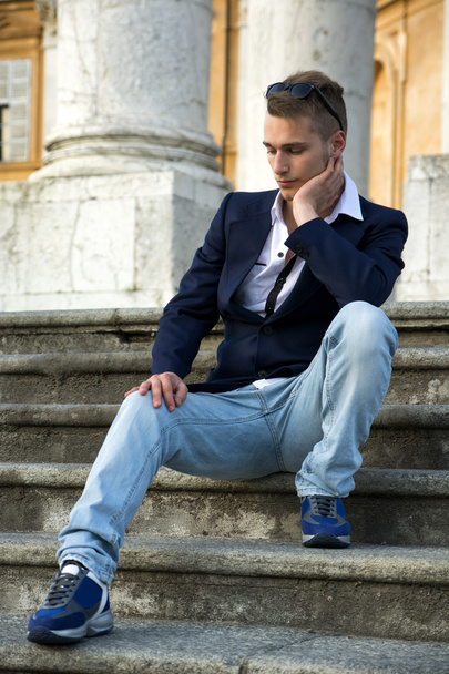 Handsome blond young man with marble columns behind him - Foto, afbeelding