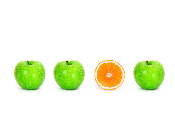 нарізане апельсинове місце на білому тлі серед зеленого яблука з краплями води, унікальна або інша концепція
 - Фото, зображення