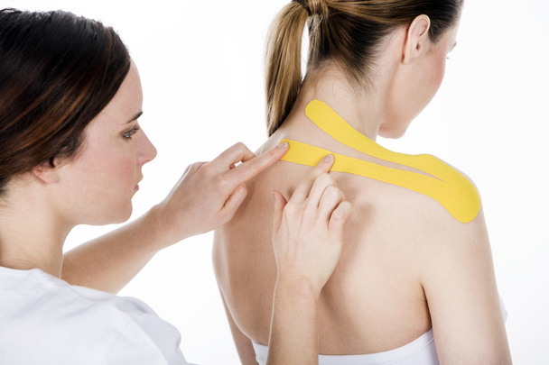 Physiotherapist gets  the taping on the trapezius - Photo, Image