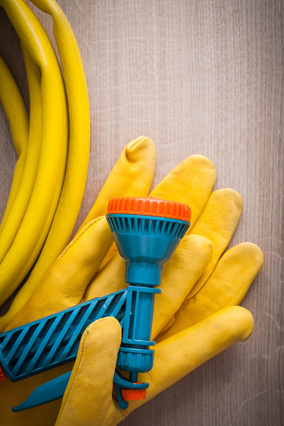 protective gloves and hand spraying hose - Foto, afbeelding
