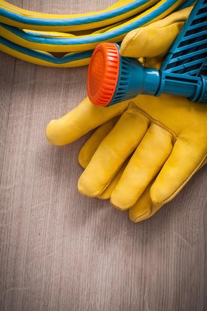 protective gloves and hand spraying hose - Φωτογραφία, εικόνα