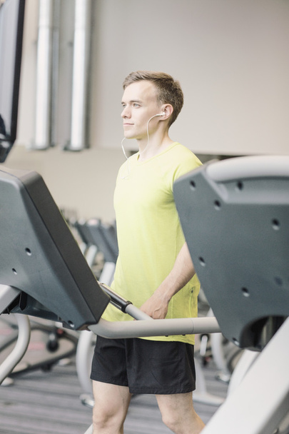 man with smartphone exercising on treadmill in gym - Foto, Imagem
