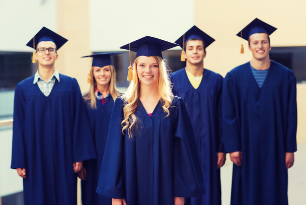 group of smiling students in mortarboards - Valokuva, kuva