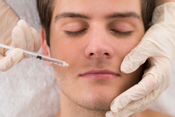 Doctor Giving Injection On Face Of Man - 写真・画像
