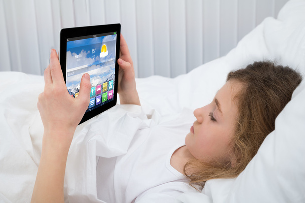 Girl Using Digital Tablet In Bedroom - Foto, afbeelding