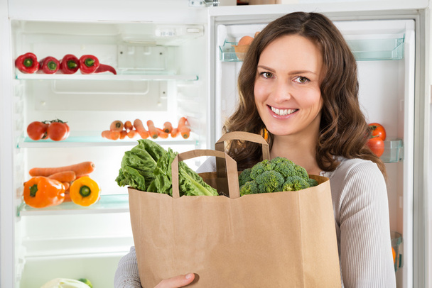 Nő a gazdaság bevásárló táska, zöldségekkel - Fotó, kép