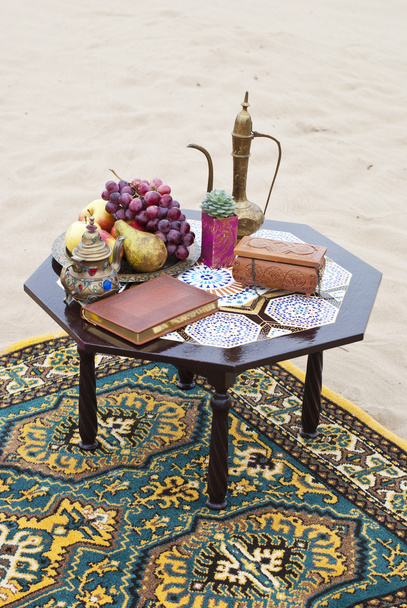 Arranjo de mesa de casamento na areia do deserto de Marrocos stile. Uvas frescas perto do salver com maçãs e peras
 - Foto, Imagem