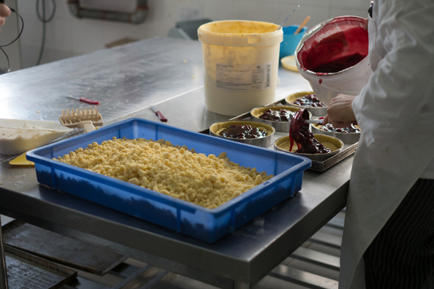 Colocando enchimento de cereja em bolos de queijo
 - Foto, Imagem