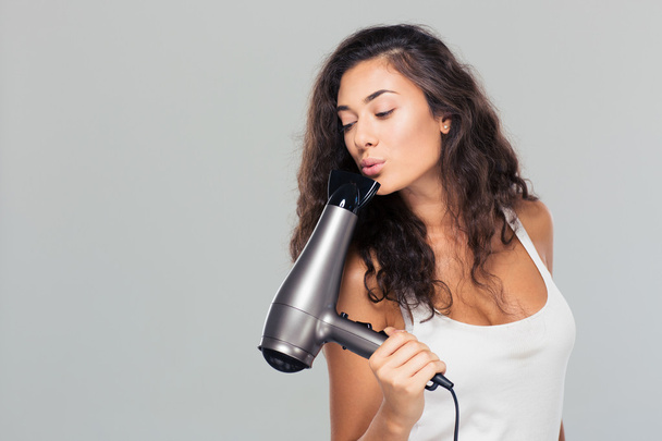 Pretty woman blowing on hairdryer  - Foto, immagini