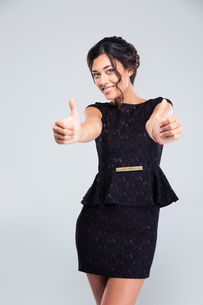 Woman in fashion dress showing thumbs up - Foto, afbeelding