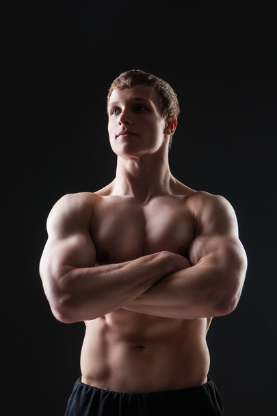 Homem jovem muscular mostra os diferentes movimentos e partes do corpo
 - Foto, Imagem