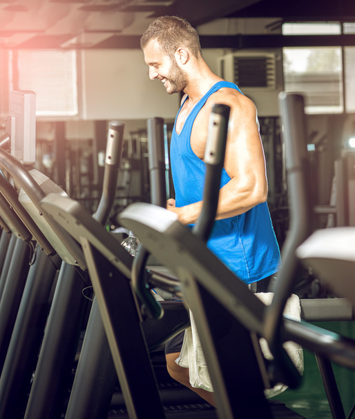 Young man running at treadmill in gym - Фото, зображення