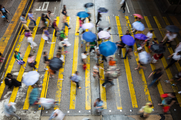 Motion blurred pedestrians crossing Hong Kong street in the rain - Photo, Image