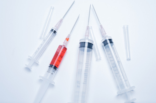 Spritzen mit rotem Impfstoff auf weißem Hintergrund - Foto, Bild