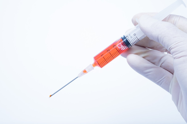 рука с красным шприцем от вакцины
 - Фото, изображение