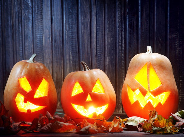 Jack o lanterns  Halloween pumpkin face on wooden background - Photo, Image