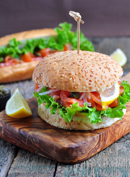 burger with pickled salmon, lettuce, white onion and capers - Foto, afbeelding