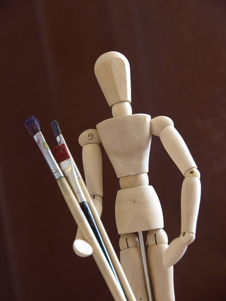 Artist's wooden mannequin with brushes - Foto, Imagen